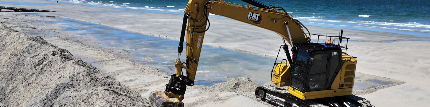 Excavator on beach for civil construction work