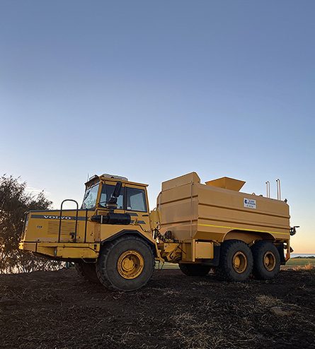 Large machinery parked near waters edge at new subdivision